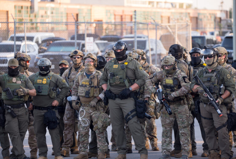 U.S. Immigration and Customs Enforcement agents, Department of Homeland Security personnel, and Border Patrol Commander Gregory Bovino stand together amidst a tense protest outside the ICE processing facility in Broadview, Illinois, on Sept. 27, 2025. (Photo by Jacek Boczarski/Anadolu via Getty Images)