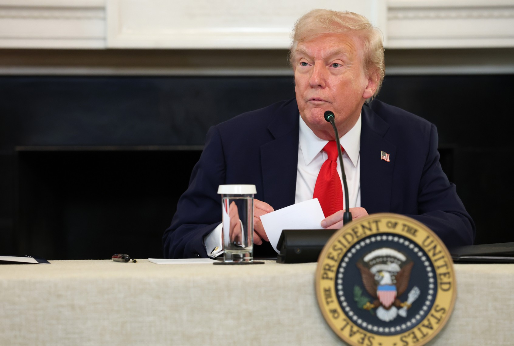U.S. President Donald Trump reads a note during a roundtable discussion in the State Dining Room of the White House on October 8, 2025 in Washington, DC. (Anna Moneymaker/Getty Images)