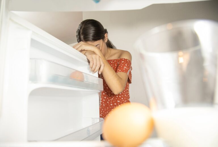 A woman cries over her empty fridge (Leonardo Moreno/Getty Images)