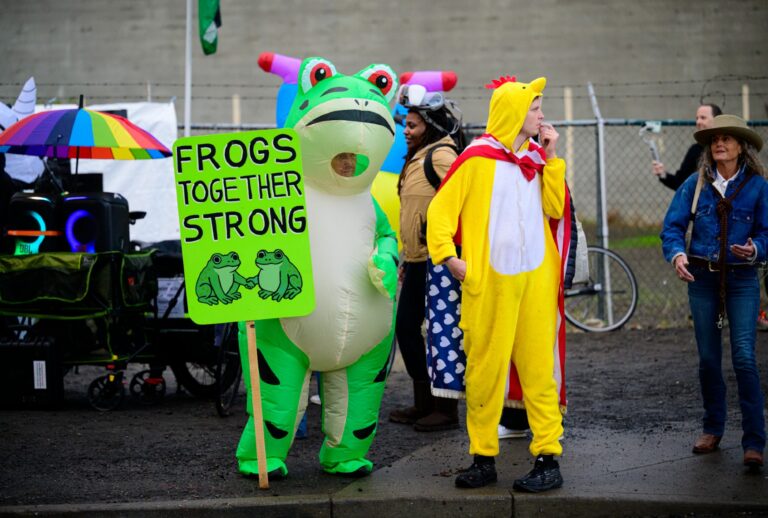 An anti-I.C.E. protester in a frog costume holds a sign at the U.S. Immigration and Customs Enforcement building on October 12, 2025 in Portland, Oregon. (Mathieu Lewis-Rolland/Getty Images)