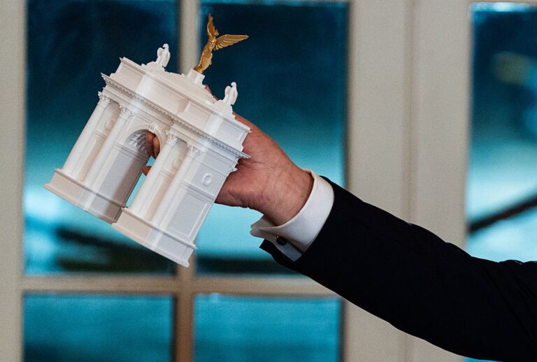 President Donald Trump holds up a model of his proposed triumph arch at the White House on Oct. 15, 2025. (Demetrius Freeman/The Washington Post via Getty Images)