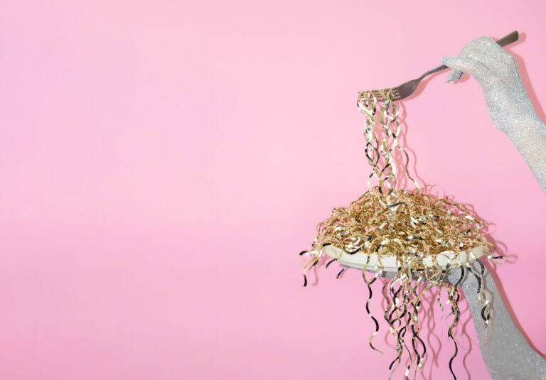 A hand holds a fork with colorful ribbon strands (Halyna Dorozhynska)