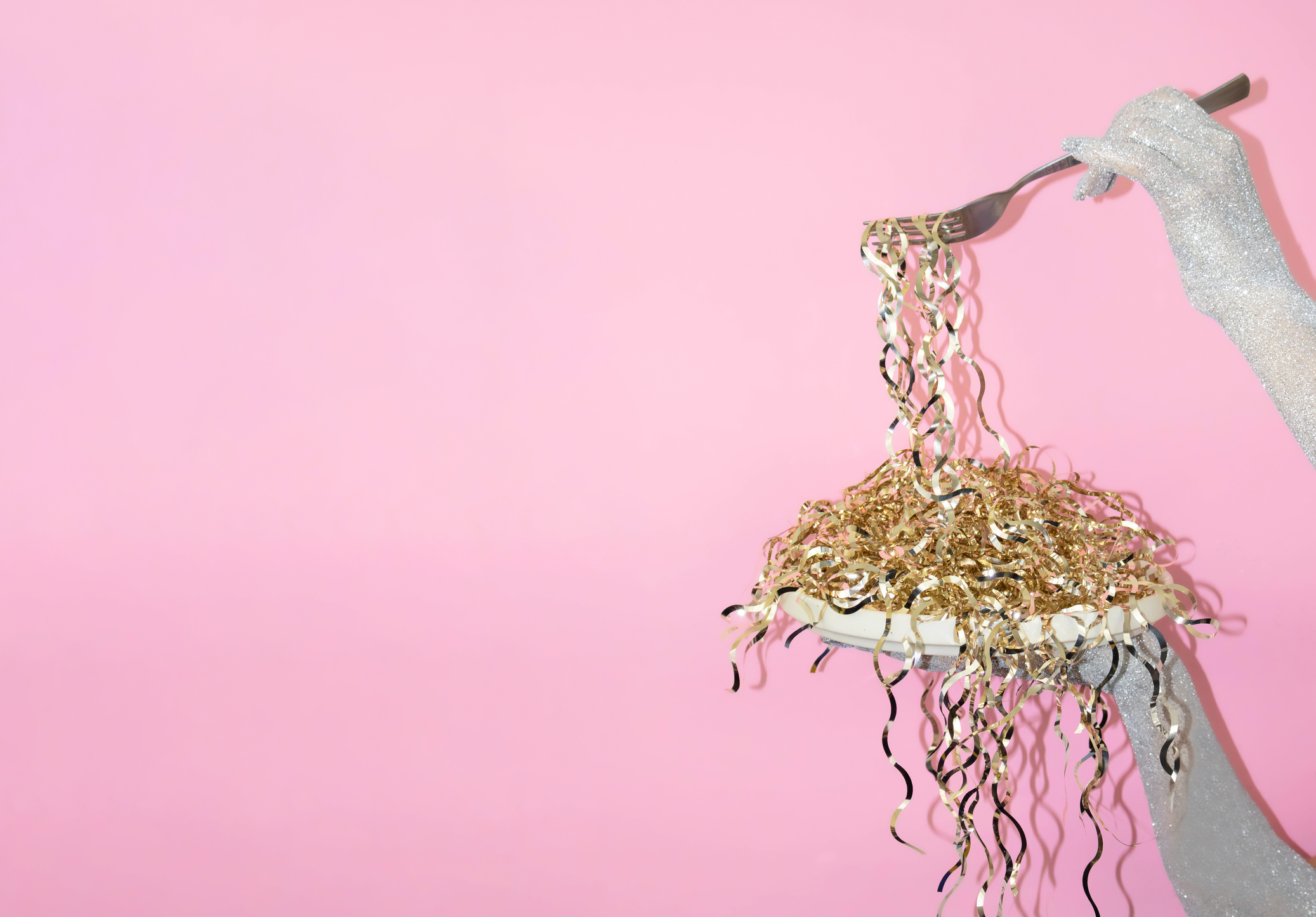 A hand holds a fork with colorful ribbon strands (Halyna Dorozhynska)