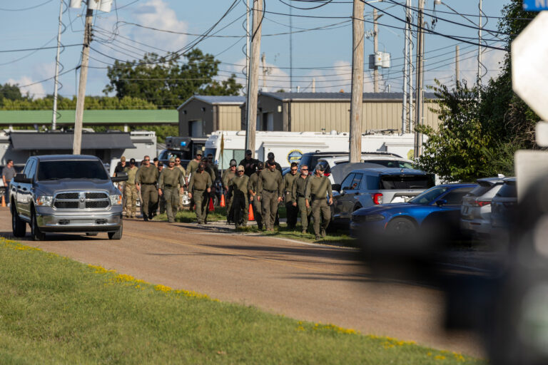Several members of law enforcement walk down Mullins Station Rd where various state and federal law enforcement agencies involved in the Memphis Safe Task Force. (Photo by Austin Johnson/ Getty Images)