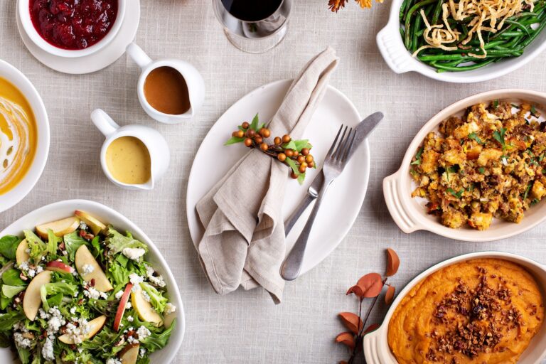 Thanksgiving dinner place setting with sides and pumpkin soup (VeselovaElena / Getty Images )