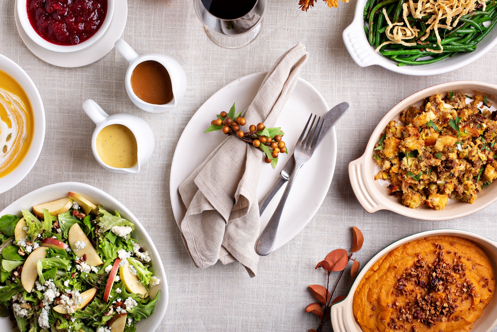 Thanksgiving dinner place setting with sides and pumpkin soup (VeselovaElena / Getty Images )