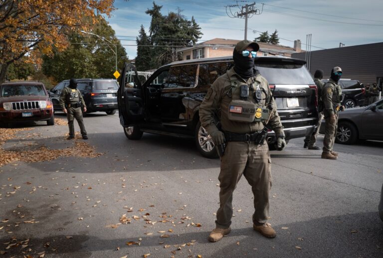 Federal agents stand guard as they are confronted by residents on November 06, 2025 in Chicago, Illinois. (Scott Olson/Getty Images)