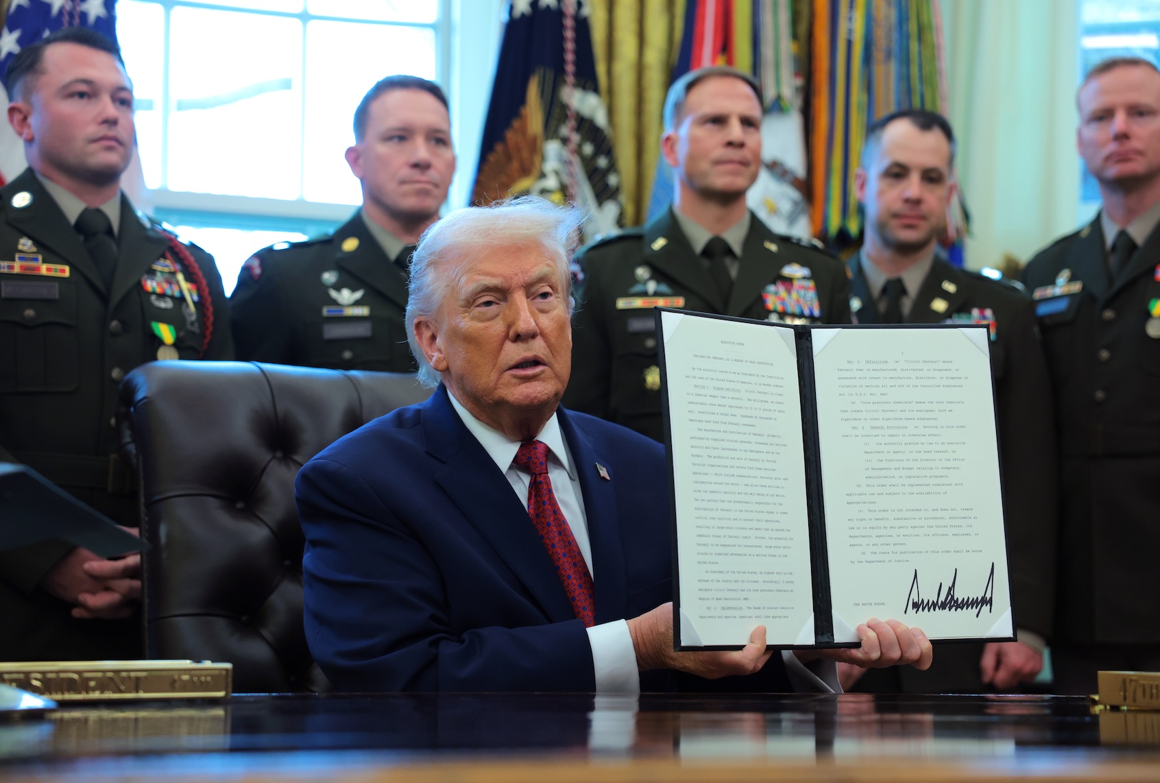 WASHINGTON, DC - DECEMBER 15: U.S. President Donald Trump poses with a recently signed executive order classifying fentanyl as a "weapon of mass destruction," during a ceremony for the presentation of the Mexican Border Defense Medal in the Oval Office of the White House on December 15, 2025 in Washington, DC. During the ceremony, Trump recognized the first 13 service members to receive the recently established Mexican Border Defense Medal (MBDM), which recognizes service members supporting Customs and Border Protection on the U.S.-Mexico border. (Photo by Anna Moneymaker/Getty Images)