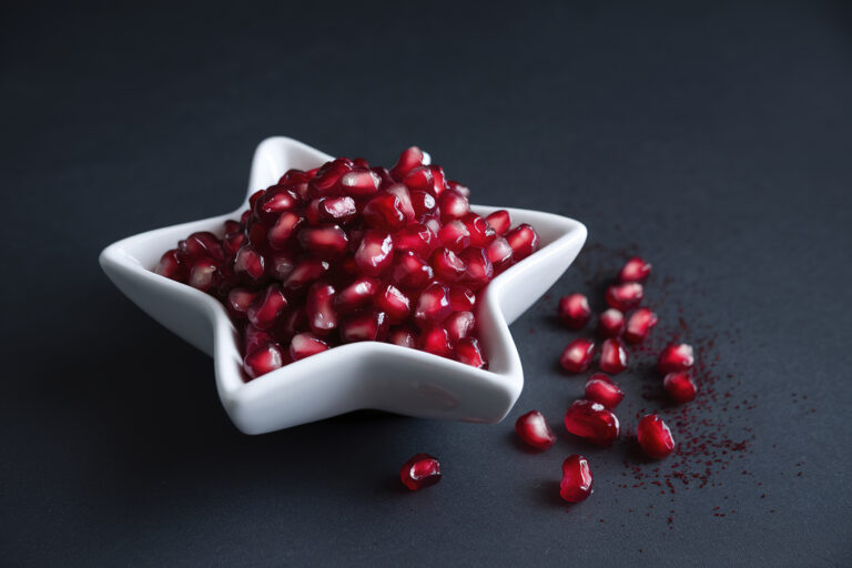 A white star-shaped bowl filled with fresh red pomegranate seeds (Horia Ionescu / 500px / Getty Images)