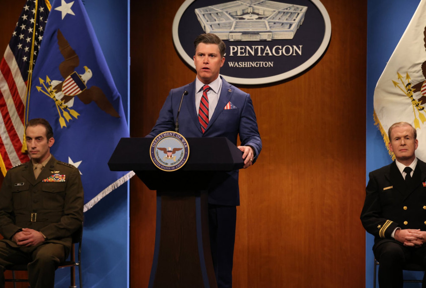 Colin Jost as Secretary of War Pete Hegseth during the "Pentagon Press Conference" Cold Open on "Saturday Night Live" (Will Heath/NBC)