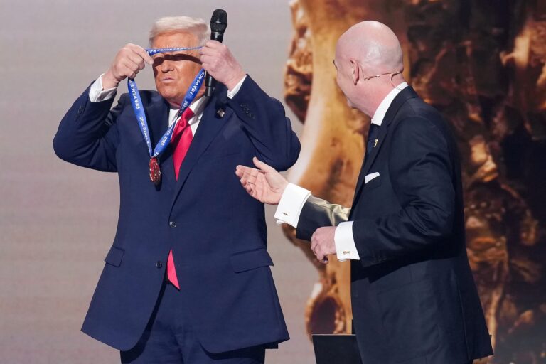 Donald Trump places the FIFA Peace Prize around his neck after receiving it from FIFA President Gianni Infantino. (Andrew Harnik/Getty Images)