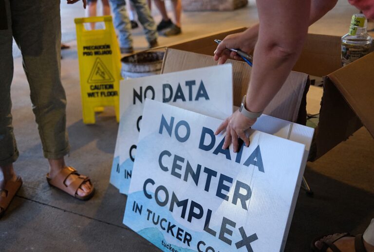 Volunteers hand out signs opposing a data center complex in Tucker County, West Virginia, following a public meeting on June 30, 2025. (ULYSSE BELLIER/AFP via Getty Images)