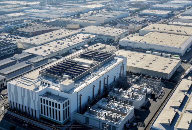 VERNON, CALIFORNIA - OCTOBER 20: An aerial view of a 33 megawatt data center (LOWER L) with closed-loop cooling system, amid warehouses on October 20, 2025 in Vernon, California. A surge in demand for AI infrastructure is fueling a boom in data centers across the country and around the globe. (Photo by Mario Tama/Getty Images)