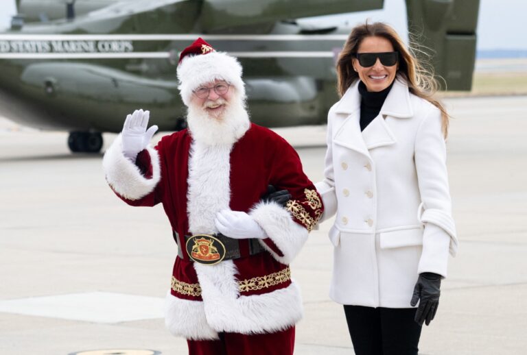 Melania Trump walks with a person dressed as Santa Claus as she arrives at Marine Corps Base Quantico for a holiday charity drive on December 8, 2025 (SAUL LOEB / AFP via Getty Images)