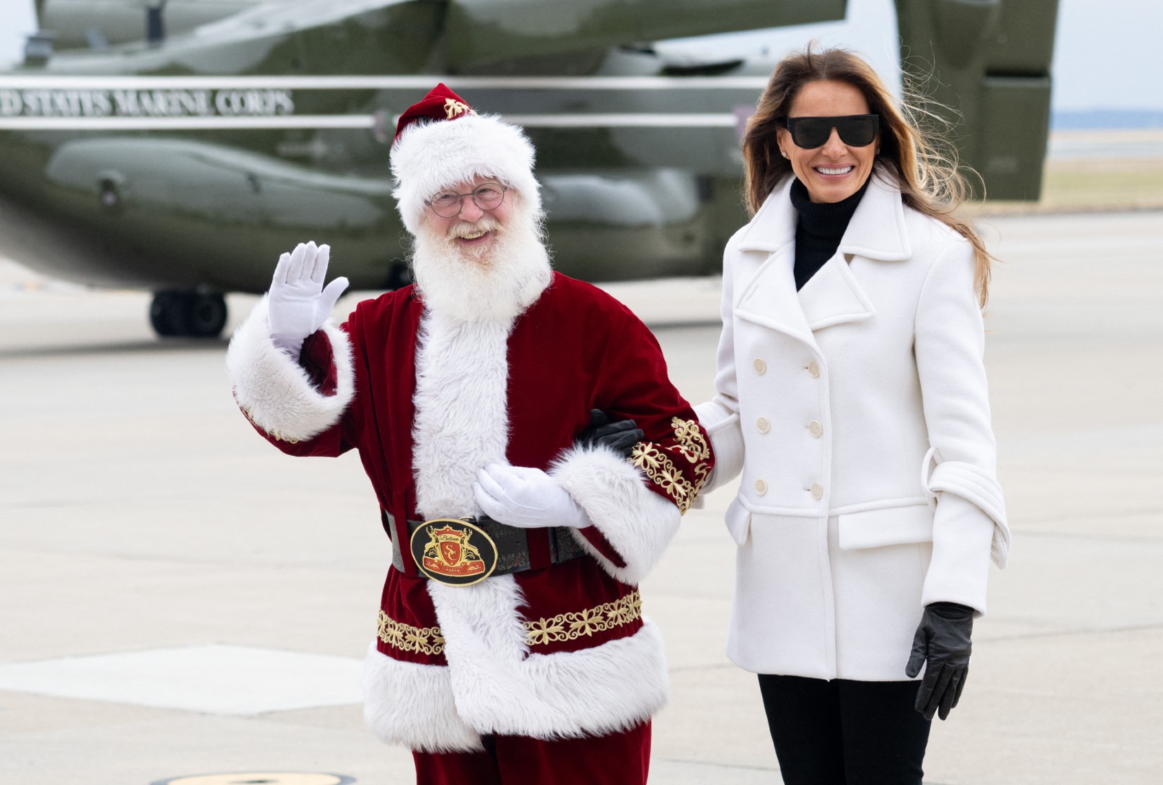 Melania Trump walks with a person dressed as Santa Claus as she arrives at Marine Corps Base Quantico for a holiday charity drive on December 8, 2025 (SAUL LOEB / AFP via Getty Images)