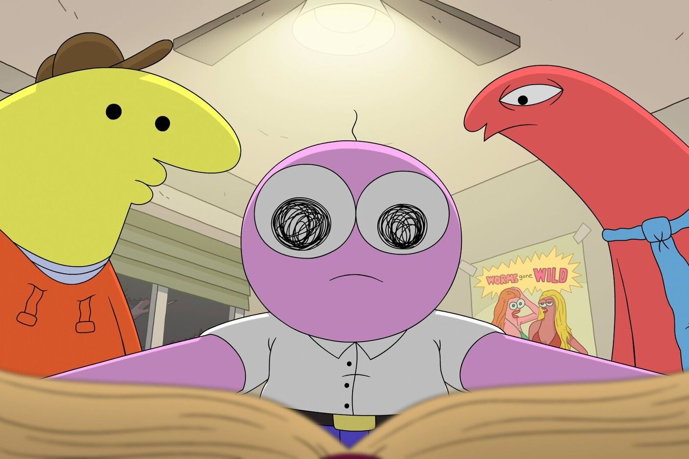 Animated still of three simplified characters staring at an open book. One is all pink with a round head and white button-down shirt, one is yellow and wears a brown hat and one is pinkish-red with a blue necktie. A poster in the background reads "Worms Gone Wild" and depicts two figures with long hair
