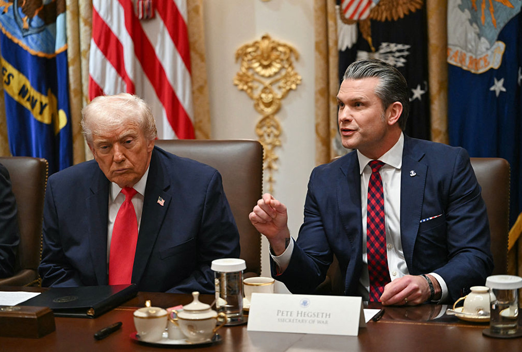 Secretary of Defense Pete Hegseth (R) speaks alongside, US President Donald Trump during a Cabinet Meeting in the Cabinet Room of the White House in Washington, DC on December 2, 2025. (ANDREW CABALLERO-REYNOLDS / AFP via Getty Images)