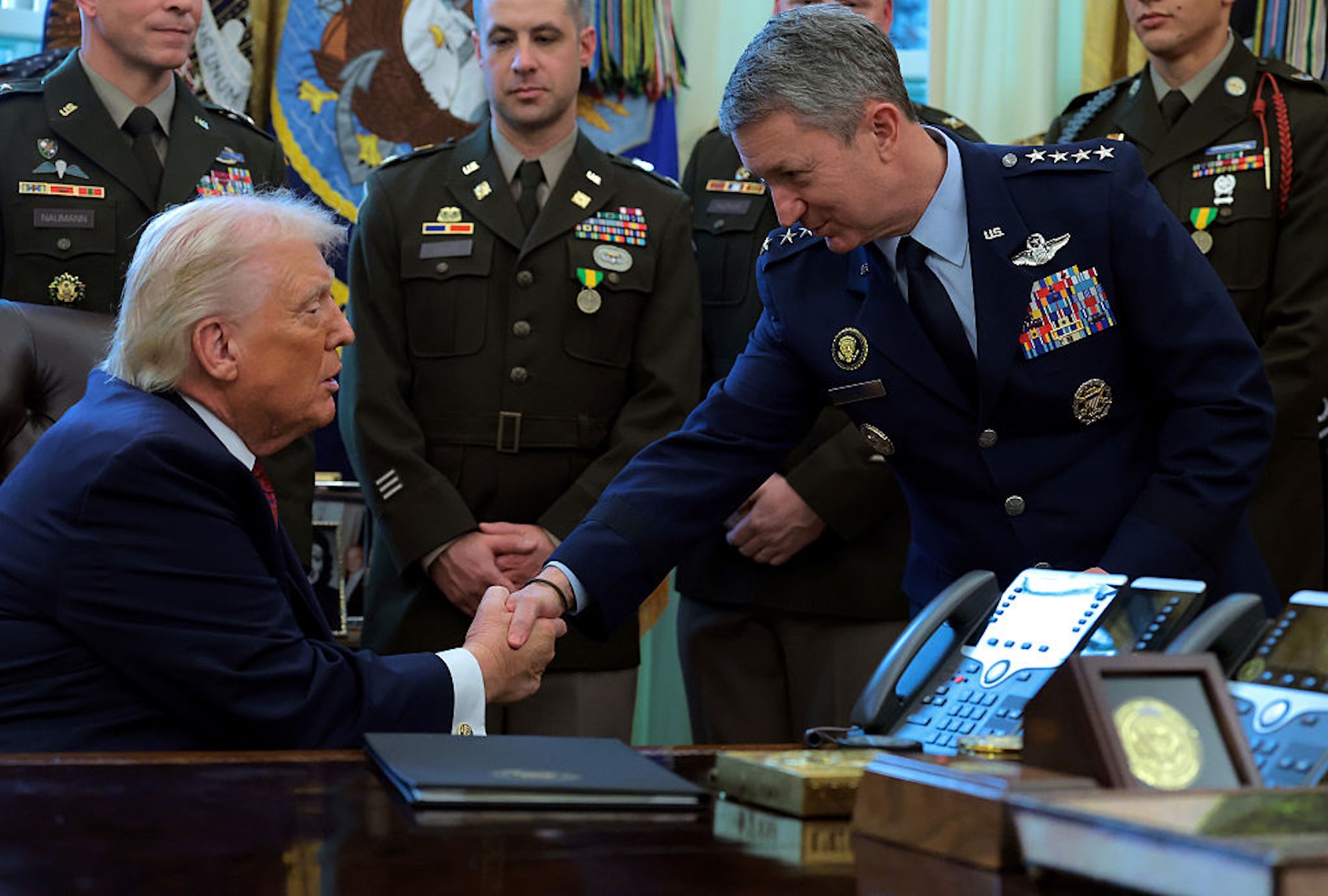 President Donald Trump 
shakes hands with Chairman of the Joint Chiefs of Staff Dan Caine. (Anna Moneymaker/Getty Images)