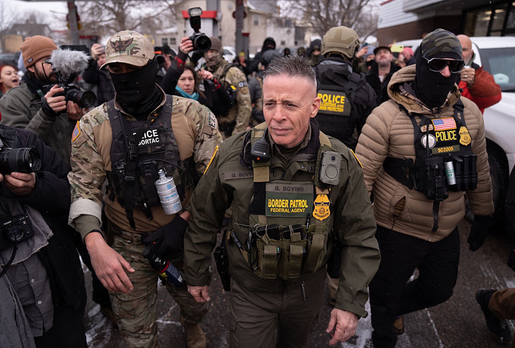 Border Patrol "commander at large" Gregory Bovino is flanked by his security team and protesters in Minnesota on Jan. 21, 2026. (Lokman Vural Elibol/Anadolu via Getty Images)