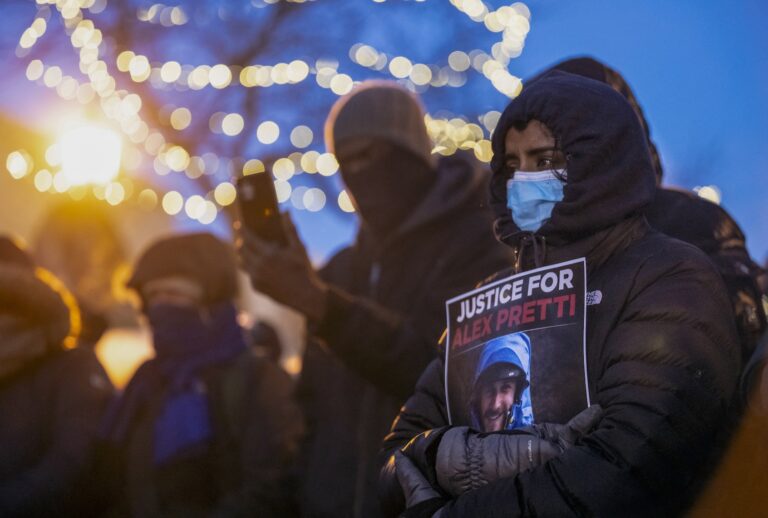 People mourn at a makeshift memorial in the area where 37-year-old Alex Pretti was shot dead by federal immigration agents earlier in the day in Minneapolis, Minnesota, on January 24, 2026. (Photo by ROBERTO SCHMIDT / AFP via Getty Images)