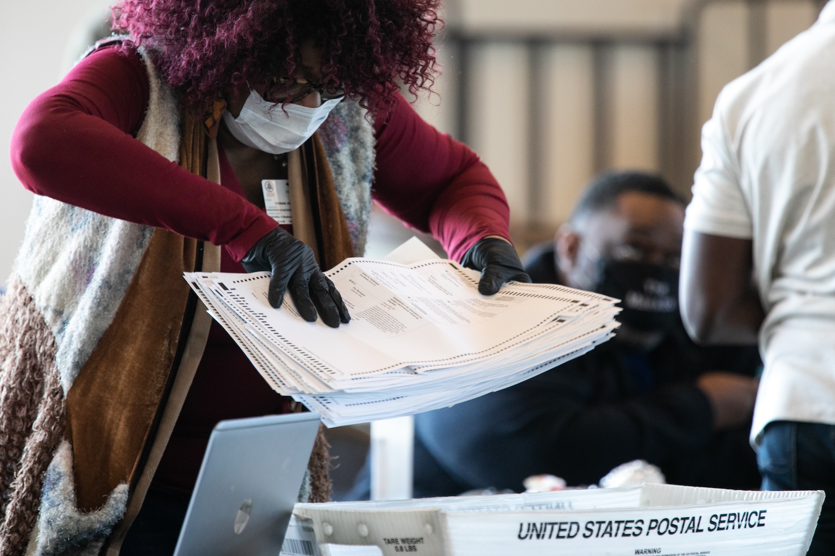 A Fulton county worker moves a stack of absentee ballots at State Farm Arena on November 6, 2020 in Atlanta, Georgia. The 2020 presidential race between incumbent U.S. President Donald Trump and Democratic nominee Joe Biden is still too close to call with outstanding ballots in a number of states including Georgia. (Photo by Jessica McGowan/Getty Images)