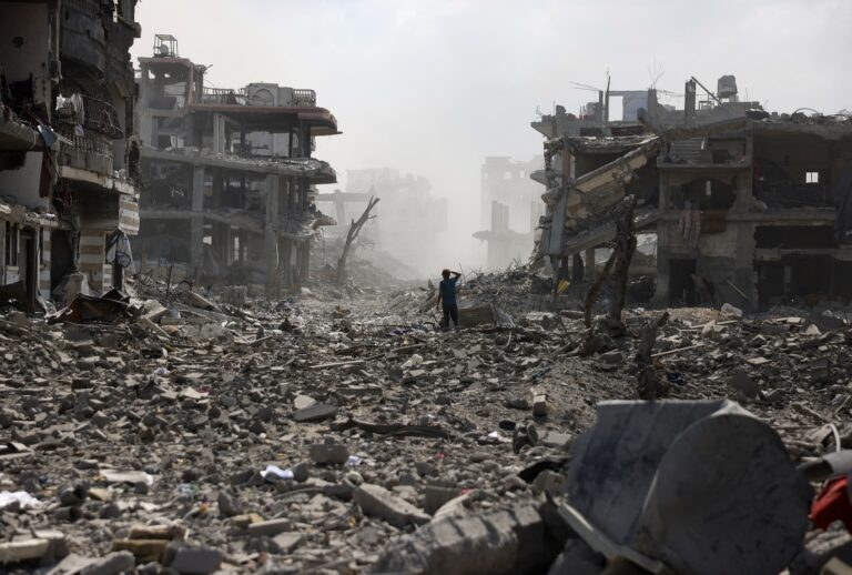 A Palestinian youth stands on a street strewn with rubble following an explosion in the Saftawi neighbourhood, west of Jabalia in the northern Gaza Strip on August 25, 2025. (Photo by BASHAR TALEB / AFP via Getty Images)