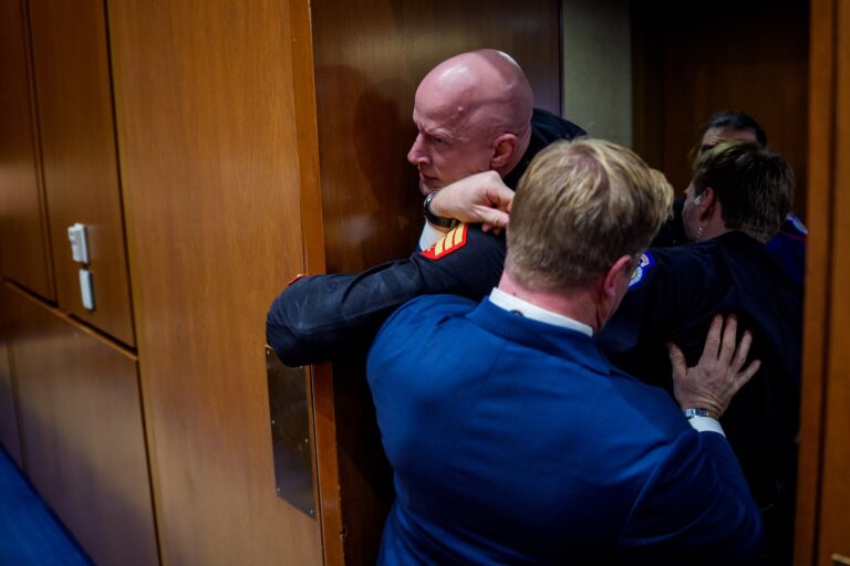 Brian McGinnis, a protester dressed in a military uniform, gets stuck in a door, injuring his arm, as Sen. Tim Sheehy (R-MT) (R) and U.S. Capitol Police officers attempt to remove him from a Senate Armed Services Subcommittee hearing on Capitol Hill on March 4, 2026 in Washington, DC. The protester has been identified as Brian McGinnis from North Carolina. The Subcommittee on Readiness and Management Support is holding a hearing to examine the current readiness of the Joint Force. (Photo by Andrew Harnik/Getty Images)