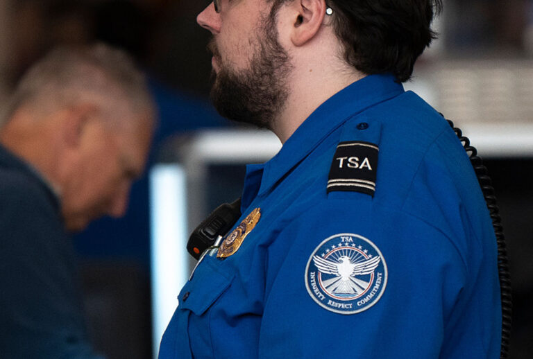 A TSA agent looks on as travelers pass through security at Minneapolis-St. Paul International Airport Terminal 1. (Photo by Stephen Maturen/Getty Images)