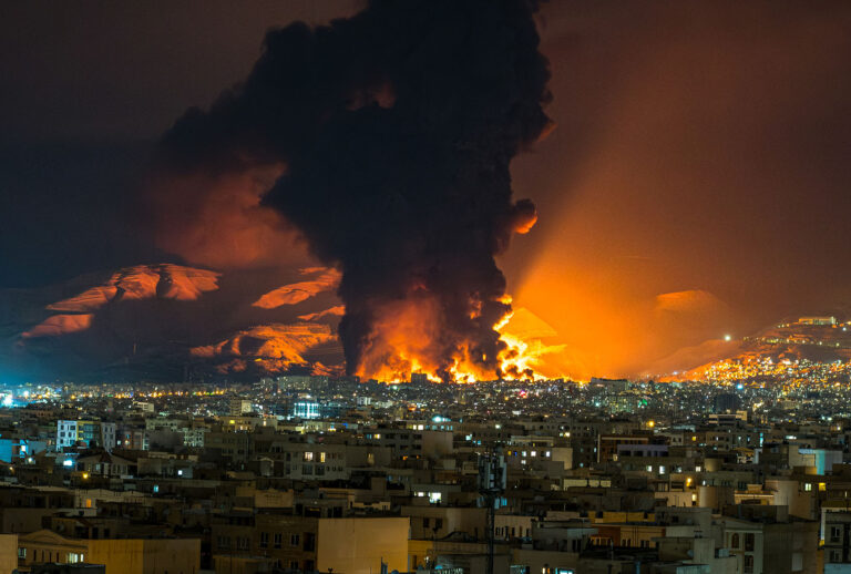 Smoke and flames rise at the site of airstrikes on an oil depot in Tehran on March 7, 2026. (Sasan / Middle East Images / AFP via Getty Images)