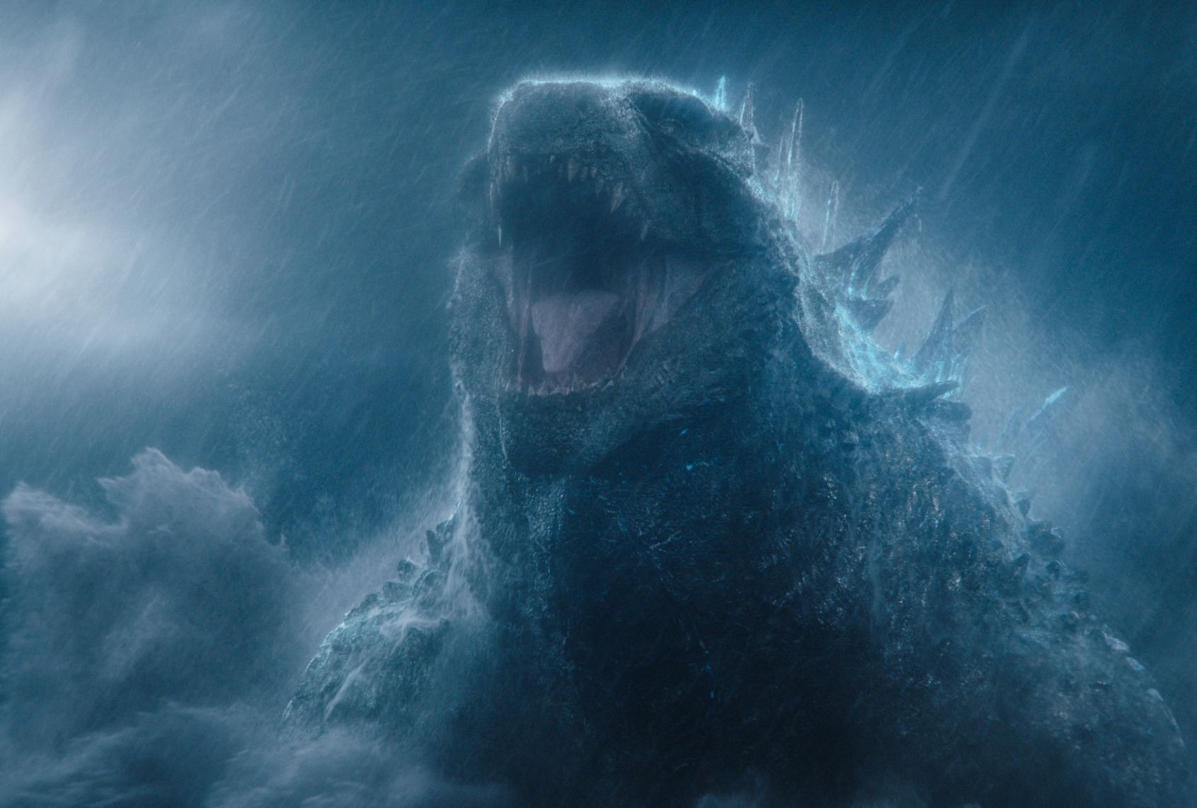 A giant dinosaur-like creature rises out of the water during a storm and roars with its mouth wide open. Lots of rain streak the sky and the waves crash in this grey and dreary scene