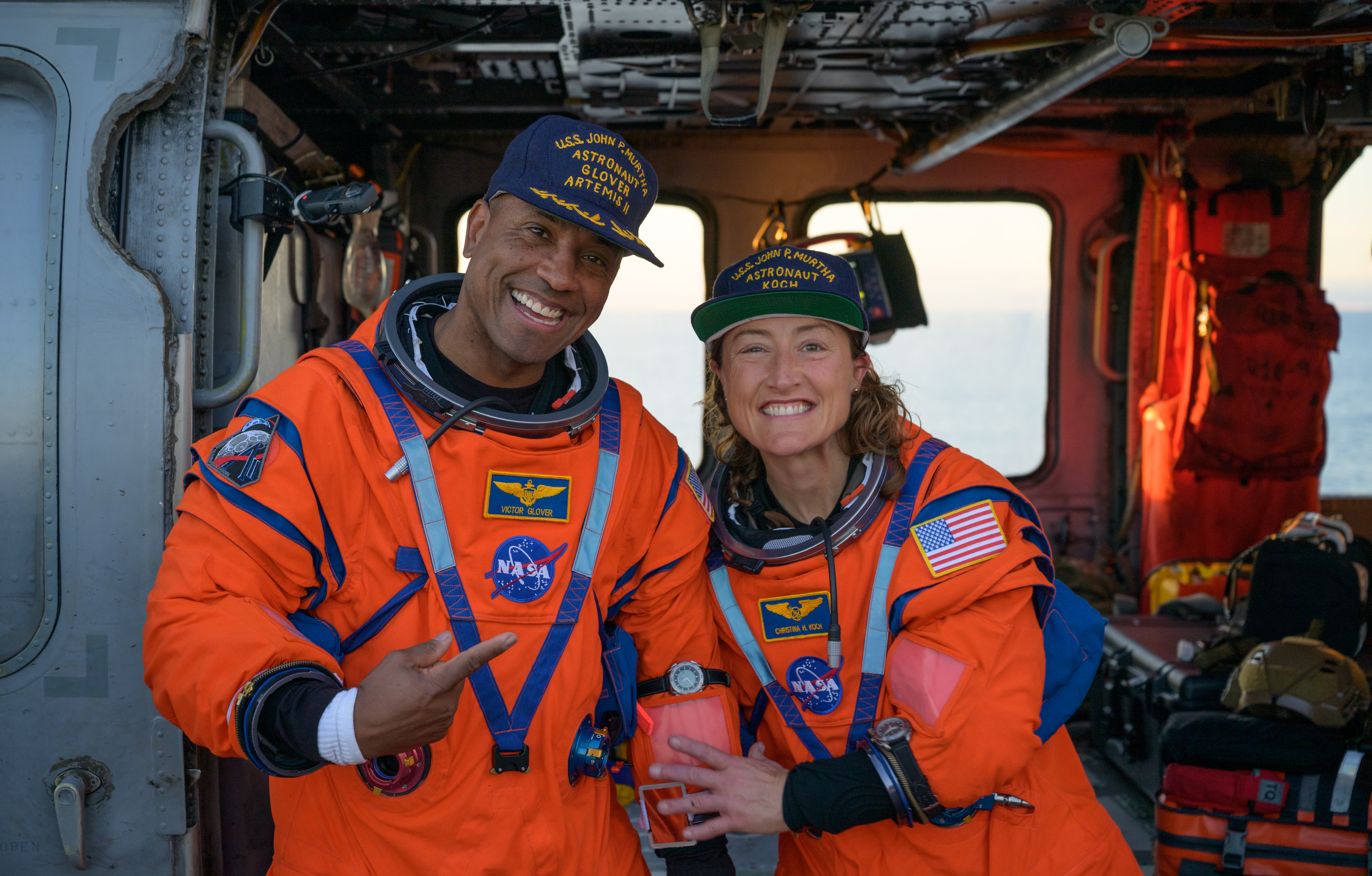 NASA astronaut Victor Glover, Artemis II pilot, left, and NASA astronaut Christina Koch, Artemis II mission specialist are seen sitting on a Navy helicopter on the flight deck of USS John P. Murtha after they and fellow crewmates CSA astronaut Jeremy Hansen, Artemis II mission specialist, and NASA astronaut Reid Wiseman, Artemis II commander, were extracted from their Orion spacecraft after splashdown. (NASA / Bill Ingalls)