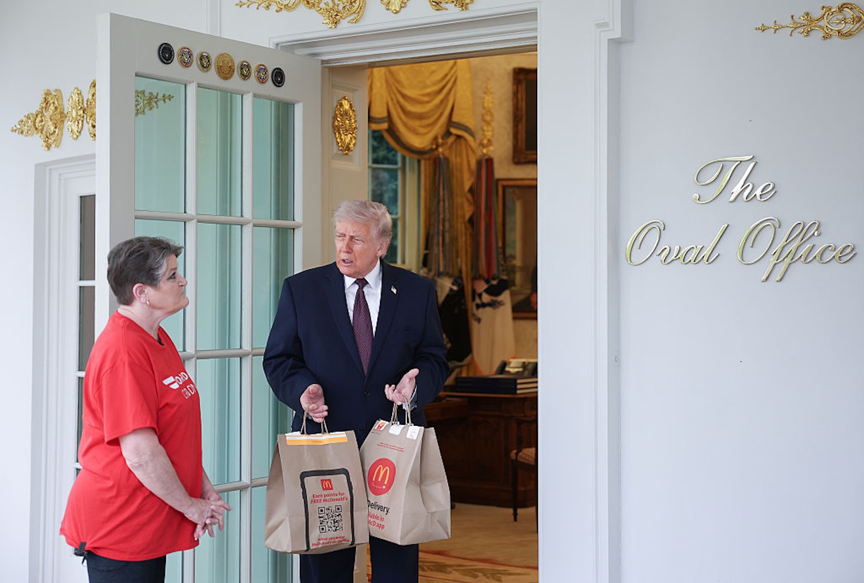 President Donald Trump receives a DoorDash delivery at the Oval Office from Sharon Simmons (Win McNamee/Getty Images)