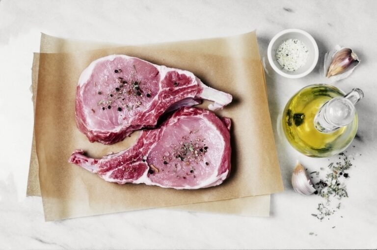Raw pork chops on butcher paper with spices (Claudia Totir / Getty Images )