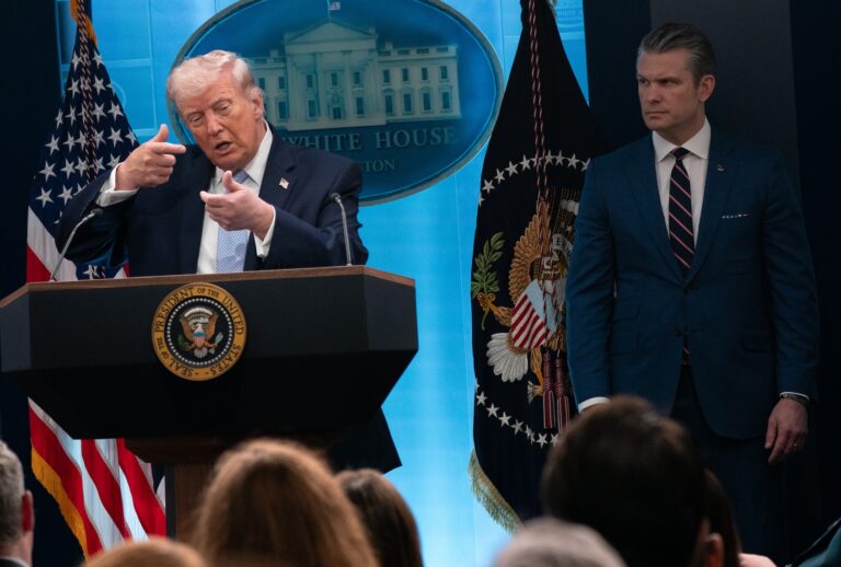 President Donald Trump mimics firing a rifle while speaking to reporters at a briefing on Monday, April 6, 2026 at the White House. (Maxine Wallace/The Washington Post via Getty Images)