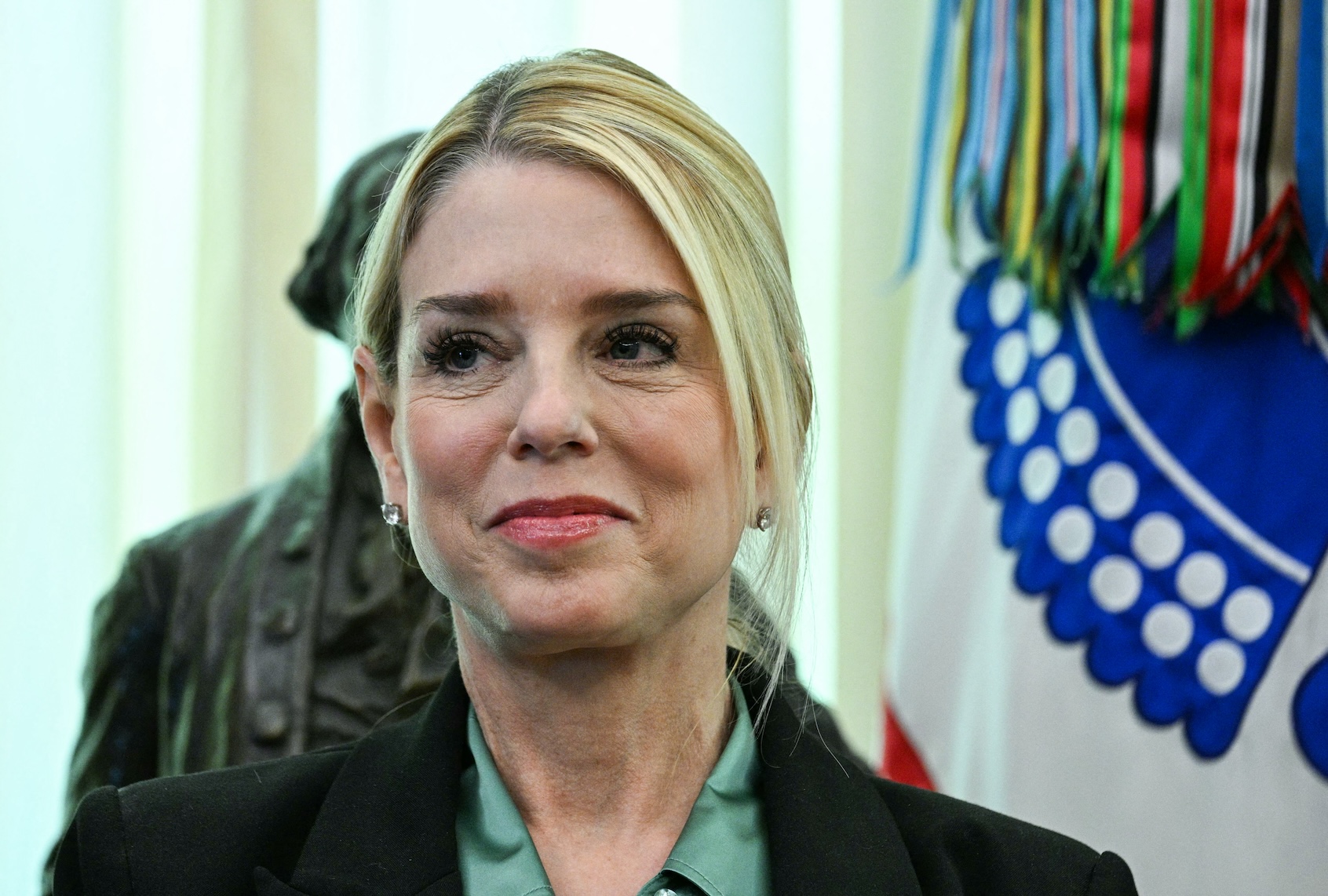 Attorney General Pam Bondi listens as US President Donald Trump speaks before swearing in the new Secretary of Homeland Security Markwayne Mullin in the Oval Office of the White House in Washington, DC, on March 24, 2026. (Photo by Jim WATSON / AFP via Getty Images)