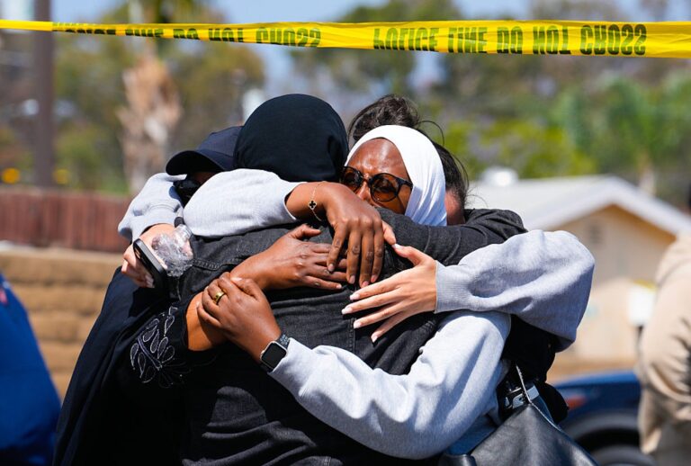 A group of people embrace near the Islamic Center of San Diego, where two teenagers allegedly shot and killed three men on May 18. The suspects were later found dead. (Kayla Bartkowski / Los Angeles Times via Getty Images)
