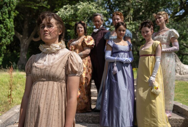 Ella Bruccoleri as Mary Bennet, Ruth Jones as Mrs Bennet, Richard E. Grant as Mr Bennet, Poppy Gilbert as Lizzie Bennet, Molly Wright as Kitty Bennet, Grace Hogg-Robinson as Lydia Bennet and Maddie Close as Jane Bennet in "The Other Bennet Sister." Credit: BBC/Bad Wolf/James Pardon (BBC/Bad Wolf/James Pardon)