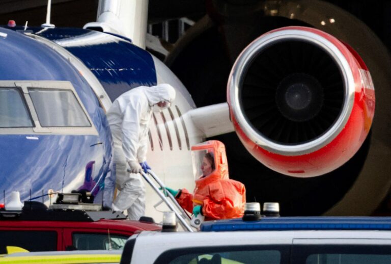 A person in a white hazmat suit disembarks medical aircraft allegedly carrying some passengers believed to be infected with hantavirus from the cruise ship MV Hondius in Amsterdam on May 6, 2026. ( Jeffrey Groeneweg / ANP / AFP via Getty Images)
