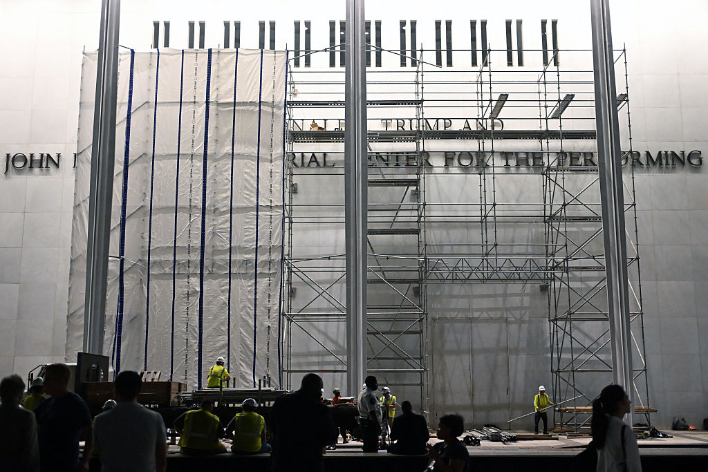 Workers set up scaffolding and a tarp to follow the court order to remove Trump's name from the Kennedy Center. Crowds gathered to watch the event late Friday night into Saturday morning. By dawn, the name was gone, but the tarp was still up. (Alex WROBLEWSKI / Getty Images)