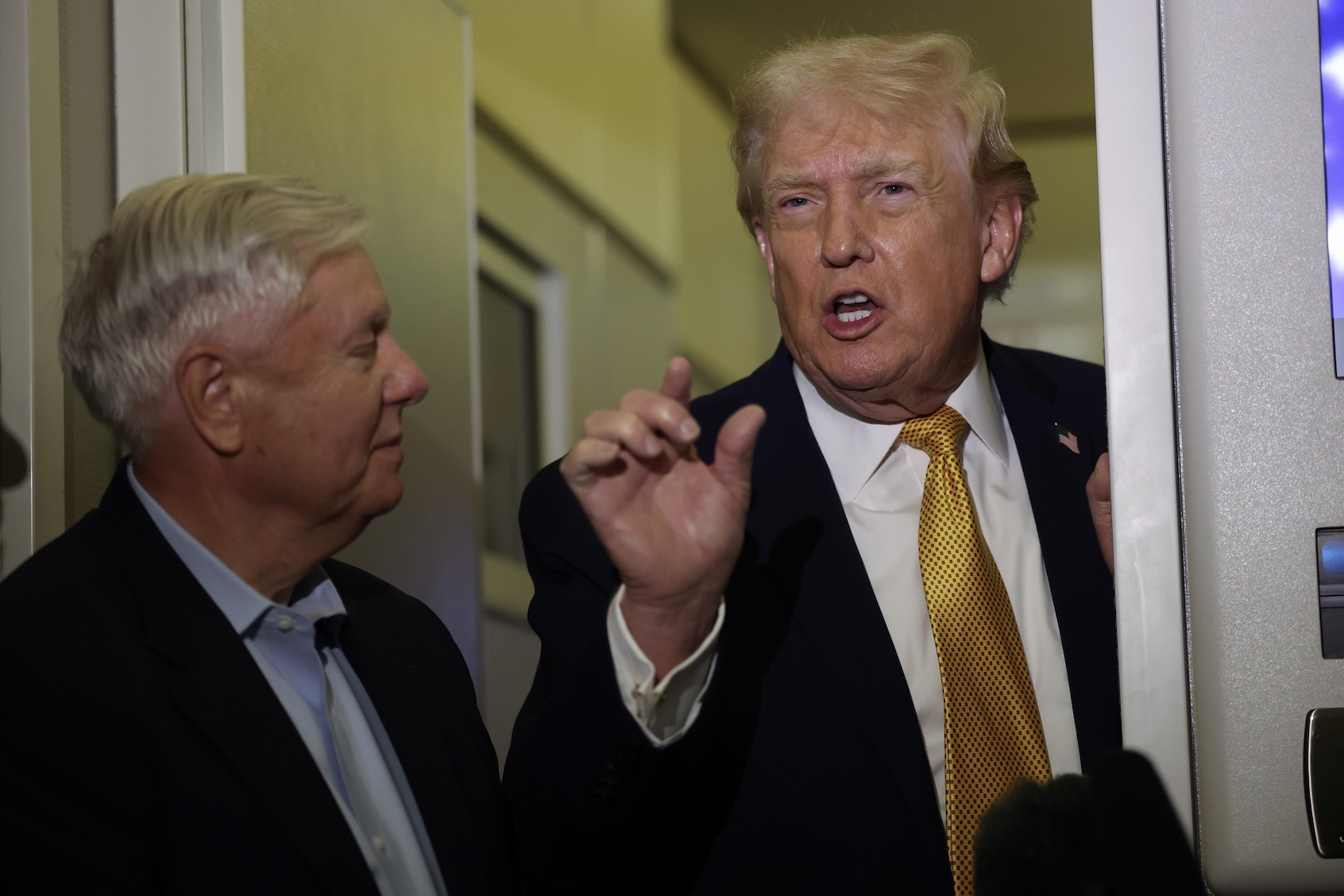 U.S. President Donald Trump (R) and U.S. Sen. Lindsey Graham (R-SC) speak to the media aboard Air Force One enroute to Washington, DC on January 04, 2026. (Photo by Joe Raedle/Getty Images)