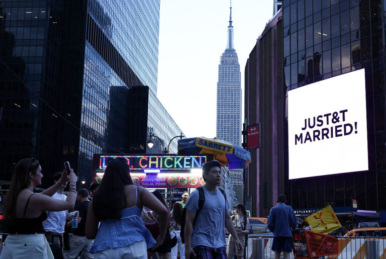A sign outside Madison Square Garden announces the wedding of Taylor Swift and Travis Kelce. Some swifities braved the heat and heavy rain to see their favorite A-listers join the party, while locals experienced the hassle of the public spectacle the private event caused to their neighborhood. (CHARLY TRIBALLEAU / Getty Images)