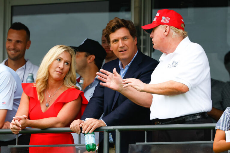 Majorie Taylor Green, Tucker Carlson and Donald Trump in 2022 before the pair split from the President over what constitutes MAGA policies. (Rich Graessle / Getty Images)