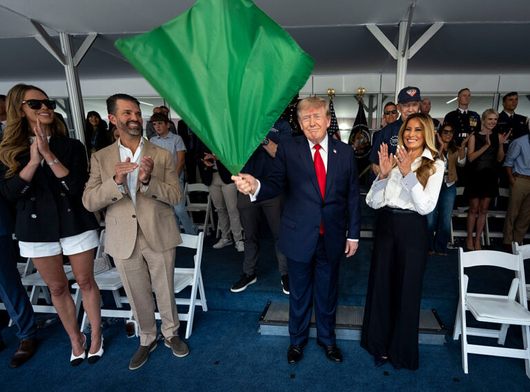 President Trump (center) waves the green flag to start the inaugural grand prix in D.C. to close this summer's 250th celebration. Those joining him in the VIP box included Melania (right) and Donald Trump Jr. and his wife Bettina Anderson. (Pool / Getty Images)