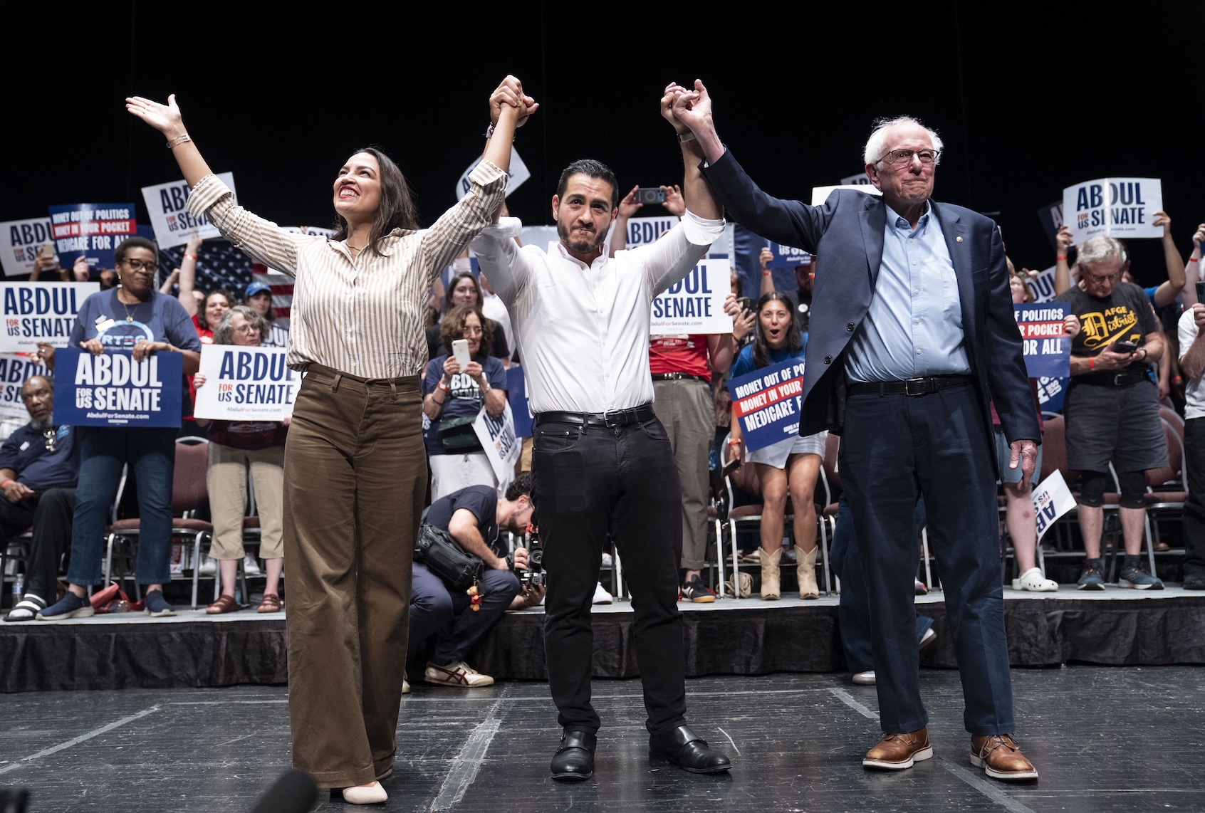 Rep. Alexandria Ocasio-Cortez (D-NY), Michigan Democratic candidate for Senate Abdul El-Sayed and U.S. Sen. Bernie Sanders (I-VT) greet the crowd after El-Sayed spoke at The People V. The Powerful rally at the Detroit Opera House on July 18, 2026 in Detroit, Michigan. (Photo by Sarah Rice/Getty Images)