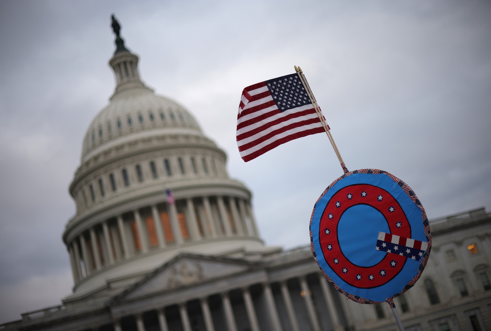 Supporters of President Donald Trump fly a U.S. flag with a symbol from the group QAnon as they gather outside the U.S. Capitol January 6, 2021 in Washington, DC. (Photo by Win McNamee/Getty Images)