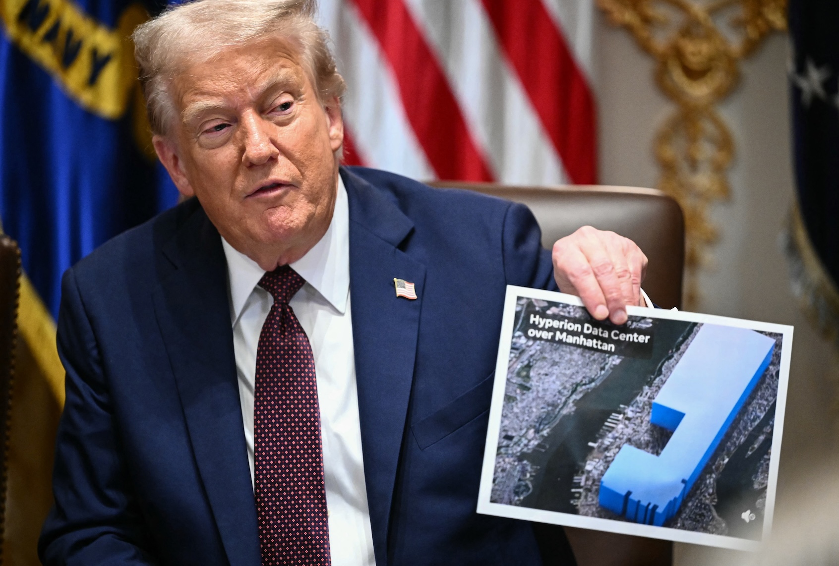 US President Donald Trump holds an image showing the size of Meta's new data center, during a cabinet meeting in the Cabinet Room of the White House in Washington, DC on August 26, 2025. (Photo by Mandel NGAN / AFP via Getty Images)