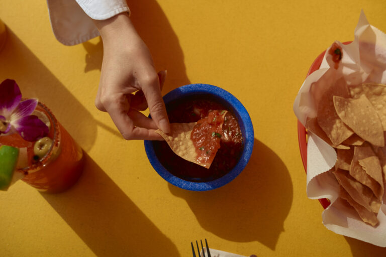 Hand reaching for chips and salsa (LB Studios / Getty Images)