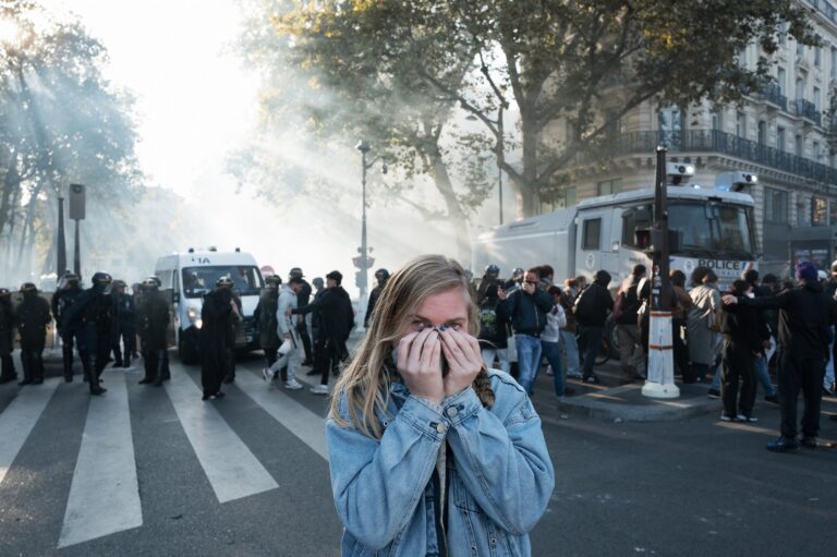 A protester reacts to tear gas fired by police at Place de la République in Paris, Oct. 18, 2026. (Jerome Gilles/NurPhoto via Getty Images)