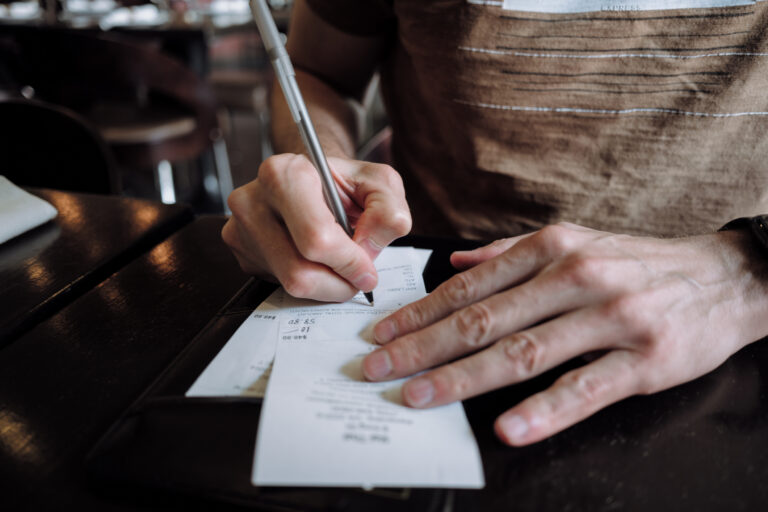 Man tipping at a restaurant (Grace Cary / Getty Images )